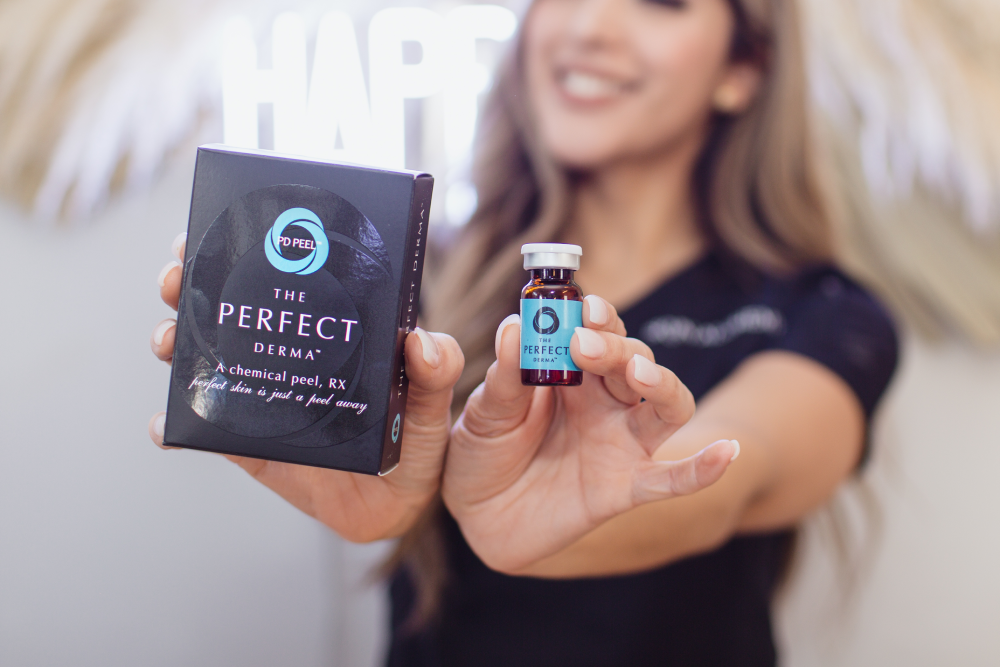 Woman holding The Perfect Derma chemical peels product.