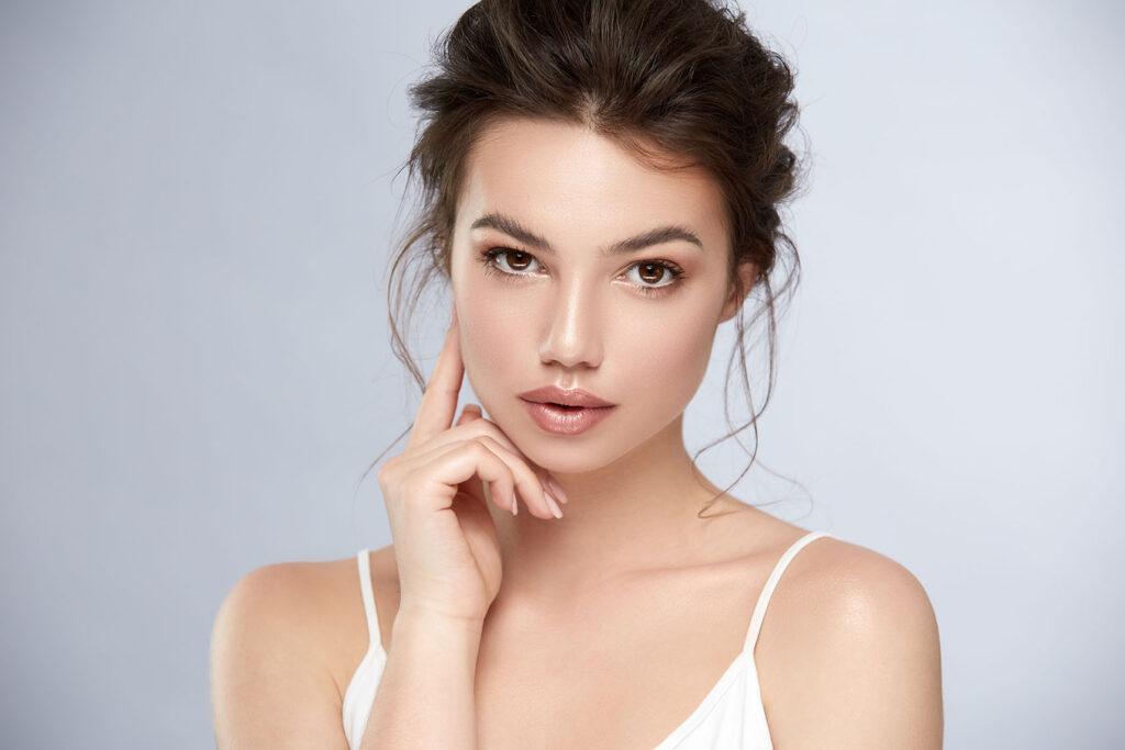Client showing smooth, glowing skin after completing a bespoke facial.