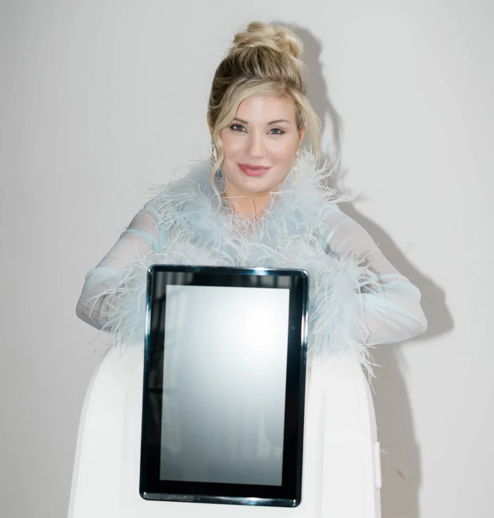 Person standing behind a Glacial FX skincare device against a light background.